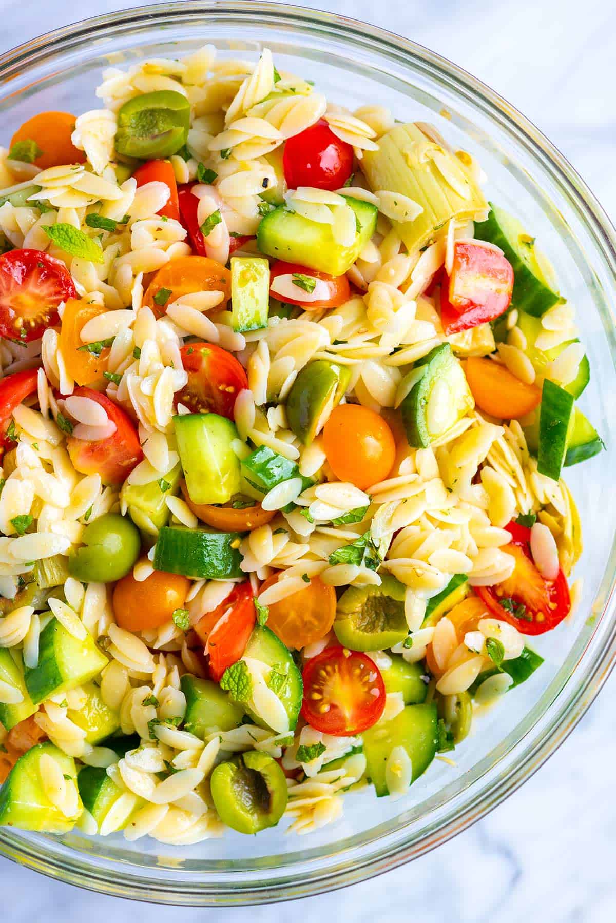 Everyone loves this easy orzo pasta salad recipe with a simple lemon vinaigrette, cucumber, olives, tomato and fresh herbs. Easy Orzo Salad